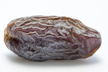 Obraz premium Close-up of a single dried date on a white backround