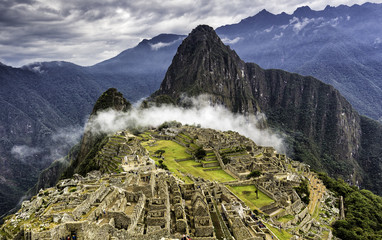 Ruinen von Machu Picchu und Huayna Picchu, bedeckt von einer mystischen Wolke. Panoramische Sommeransicht von oben.