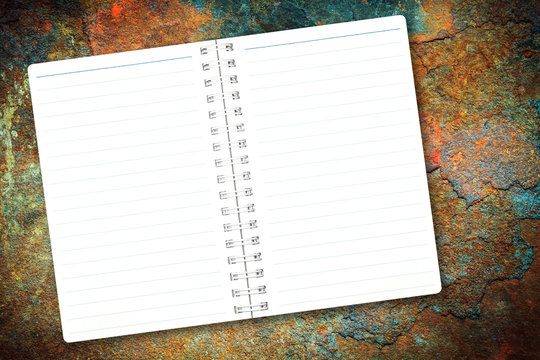Open notebook paper page with blue line on rusty metal background for design with copy space for text or image.