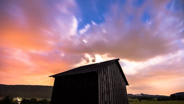 Schnell ziehende Wolken &uuml;ber alter H&uuml;tte, Tag zu Nacht Wechsel mit Sternen, im Mondlicht 16:9