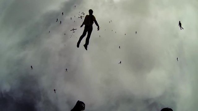 Skydivers falling in grey sky from airplanes. Making formation. Extreme. Height. Cloudness sky