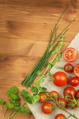 Fresh cherry tomatoes on rustic wooden background. Fresh vegetables on the kitchen table. Preparation of dietary supplements.
