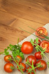 Fresh cherry tomatoes on rustic wooden background. Fresh vegetables on the kitchen table. Preparation of dietary supplements.

