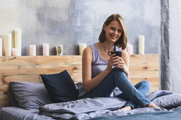 young attractive girl drinking coffee in bed