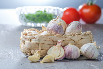 Korb mit Knoblauch auf einer Schieferplatte