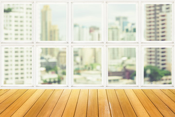 Wooden table beside white window with city view
