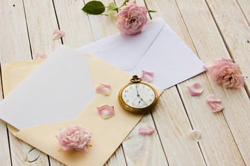 Two envelope with a card inside, old pocket watch and a rose lyi