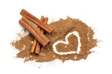 Cinnamon sticks and Heart shape hand drawn in cinnamon powder on white background