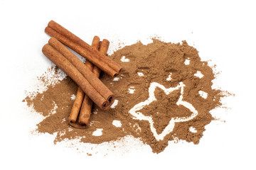 Cinnamon sticks and Star shape hand drawn in cinnamon powder on white background