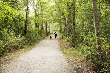 Fototapeta premium Women running with dog in the woods