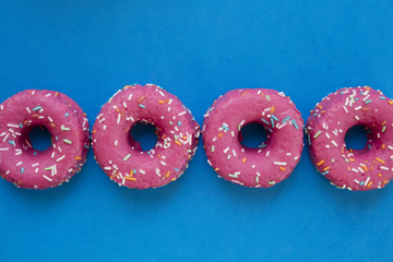 Group of glazed pink donuts on a blue background