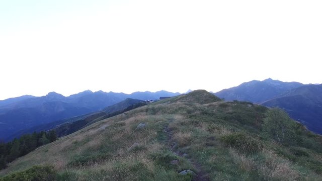 hiking, walking, trekking outdoors on mountain trail path after sunset, 4k front pov (point of view)