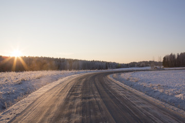 A very slippery road during winter. Black ice is covering the whole road and it is dangerous to drive even with studded winter tires. 