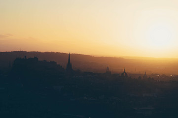 Foggy sunset over the silhouette of Edinburgh cityscape skyline