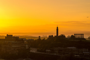 Foggy sunset over the silhouette of Edinburgh cityscape skyline,