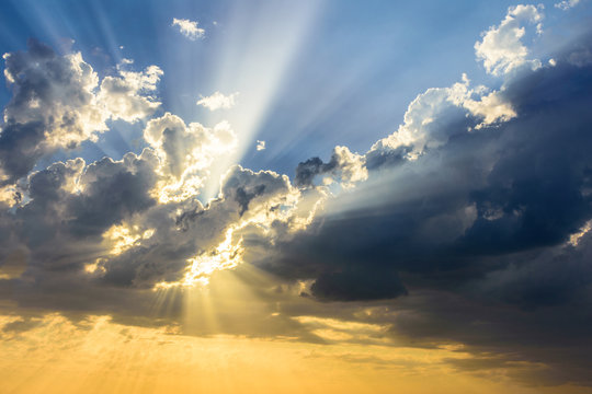 Sun beams breaking through the clouds at sunset. Beautiful 