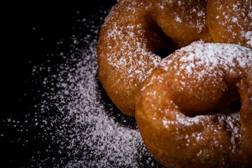 Sprinkling sugar powder on donut