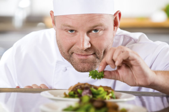 Close-up of smiling chef prepare steak dishes at restaurant