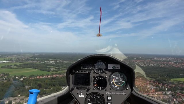 Cockpit point of view POV footage in modern glider sailplane flying in straight line showing advanced instrument panel with gauges reading altitude airspeed ascending speed beautiful day blue sky 4k