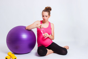 pregnant woman practicing yoga on a light background