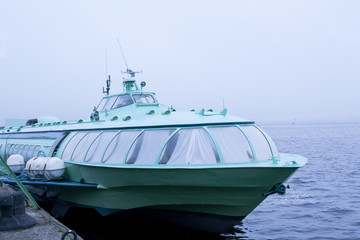 Passenger hydrofoil boat on the docks of Onego lake in foggy weather, Petrozavodsk, Karelia, Russia.