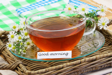 Good morning card with chamomile tea on wicker tray, closeup
