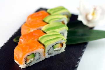 Red and green sushi on the black slate close up Salmon sushi and avocado sushi on black slate close up 