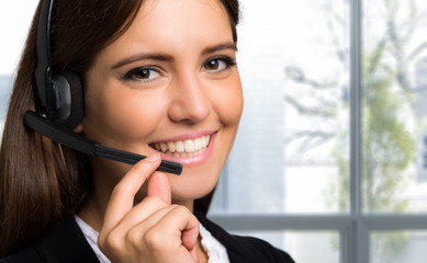 Female customer support operator with headset and smiling 