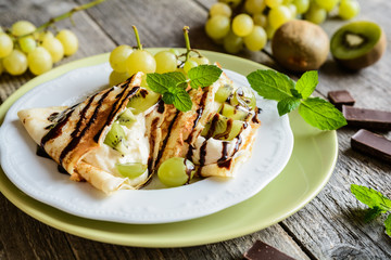 Pancakes with mascarpone filling, kiwi, grape and chocolate topping