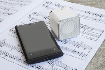 Wireless speaker and cell phone on a musical score