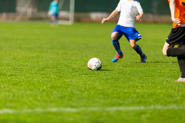 Blurred soccer players on green pitch