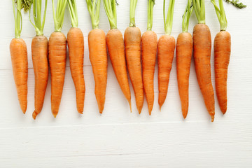 Fresh and sweet carrots on a white wooden table