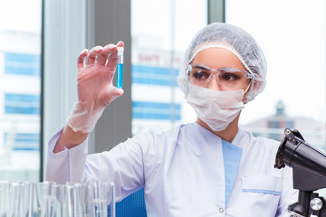 Young student working with chemical solutions in lab