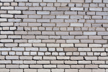 Weathered grey brick wall texture.