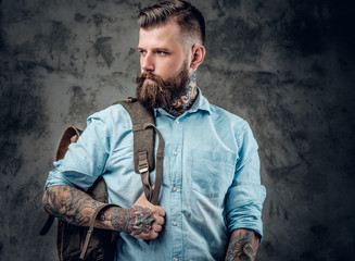 A man with tattoos on his arms and neck with backpack on his bac