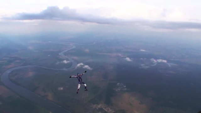 Skydiver free style in evening cloudy sky. Speed. Extreme sport. Falling. Landscape