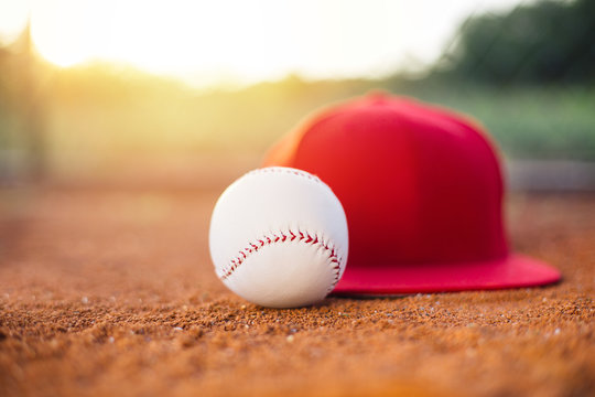 Baseball cap and ball on field