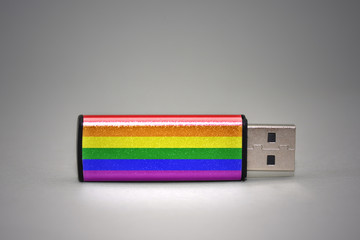 usb flash drive with the gay rainbow flag of on gray background.