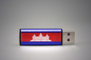 usb flash drive with the national flag of cambodia on gray background.