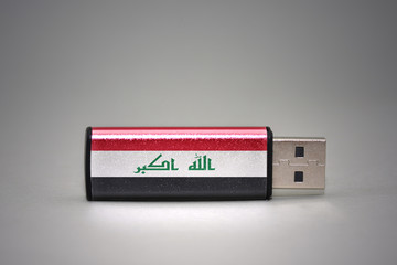 usb flash drive with the national flag of iraq on gray background.