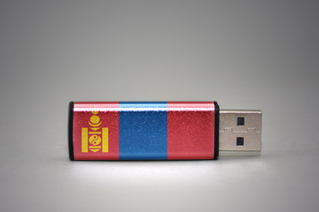 usb flash drive with the national flag of mongolia on gray background.