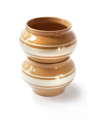 Stack of twoo glazed ceramic pots for cooking on a white backgro