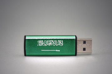 usb flash drive with the national flag of saudi arabia on gray background.