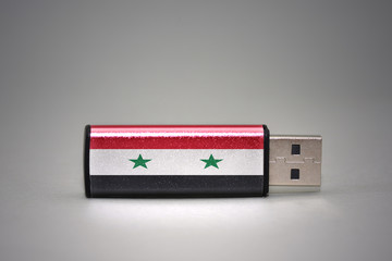 usb flash drive with the national flag of syria on gray background.