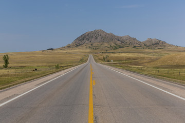 Fototapeta na wymiar Bear Butte Highway / A highway leading to a butte.