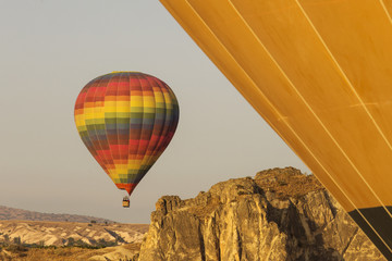 Hot air balloon flying over rock landscape at Cappadocia Turkey