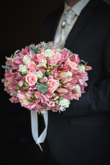 Wonderful wedding bouquet of alstroemeria in the hands of the gr