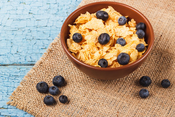 Portion of corn flakes in the bowl with blueberries