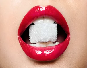 Schöne rote weibliche Lippen mit einem Stück Zucker im Mund © deniskomarov