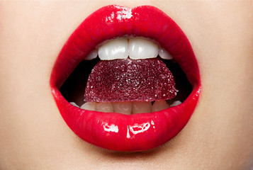 Beautiful red lips with a piece of fruit jelly - obrazy, fototapety, plakaty